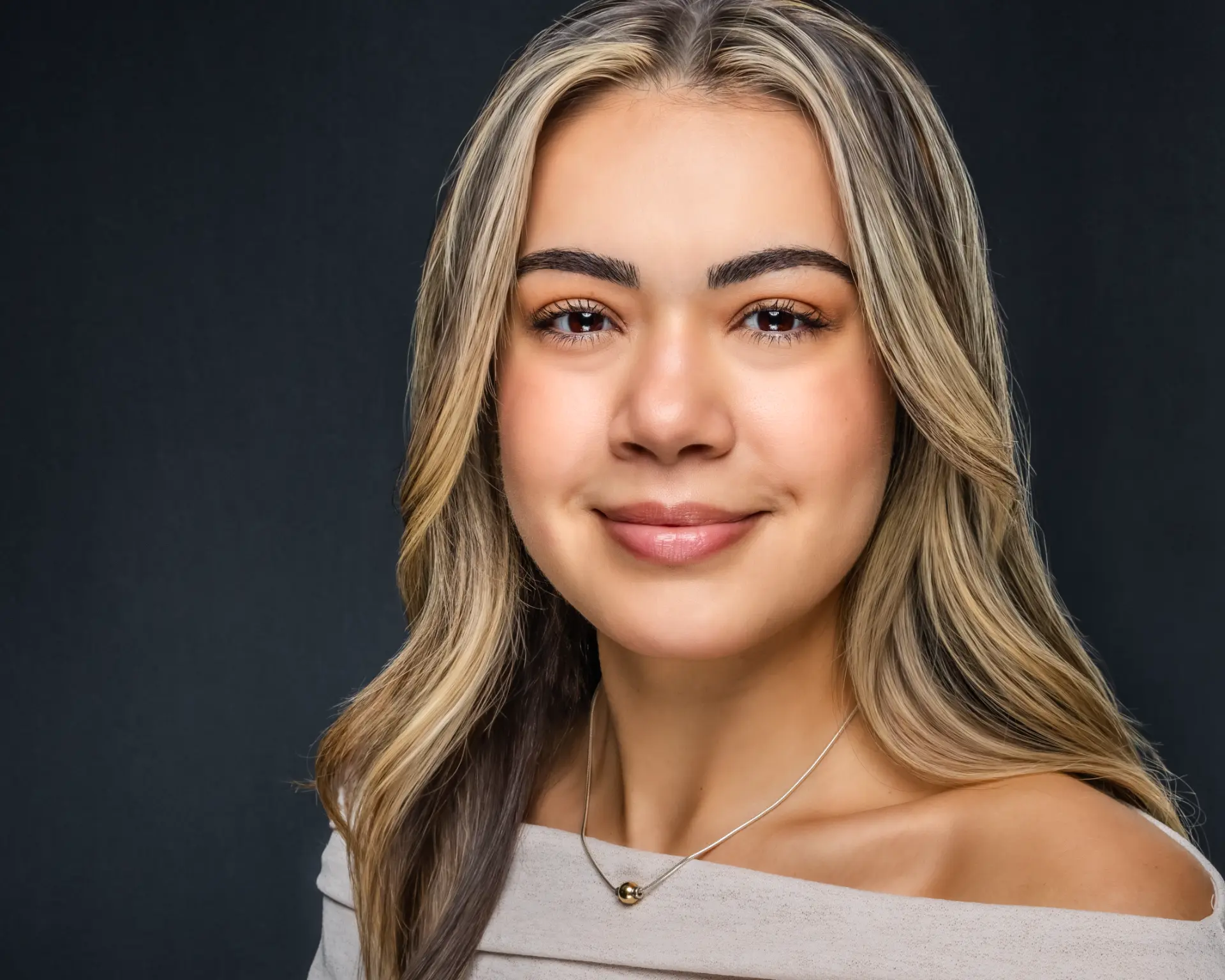 Studio headshot of a young professional woman with long blonde hair